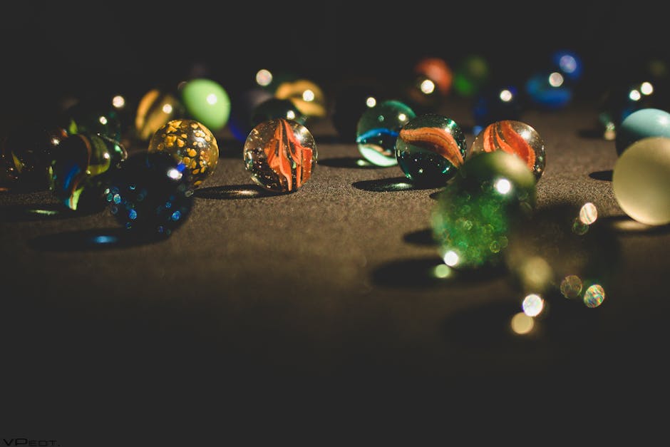 Storing and Displaying Vintage Marbles: Complete Preservation Guide A vibrant collection of glass marbles glistening on a dark surface, showcasing rich colors and textures.
