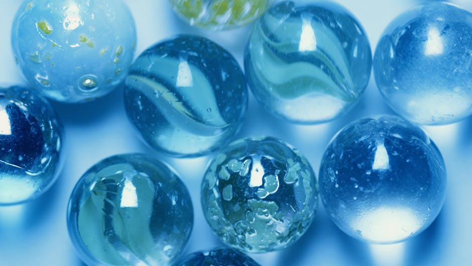 A detailed close-up shot of translucent blue marbles with light reflections and smooth textures.